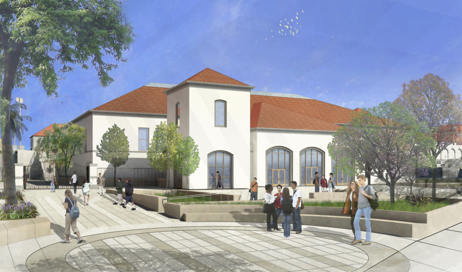 Rounded intersection with stone bench seating in courtyard. Behind, a white Spanish style 2 story building with red roof