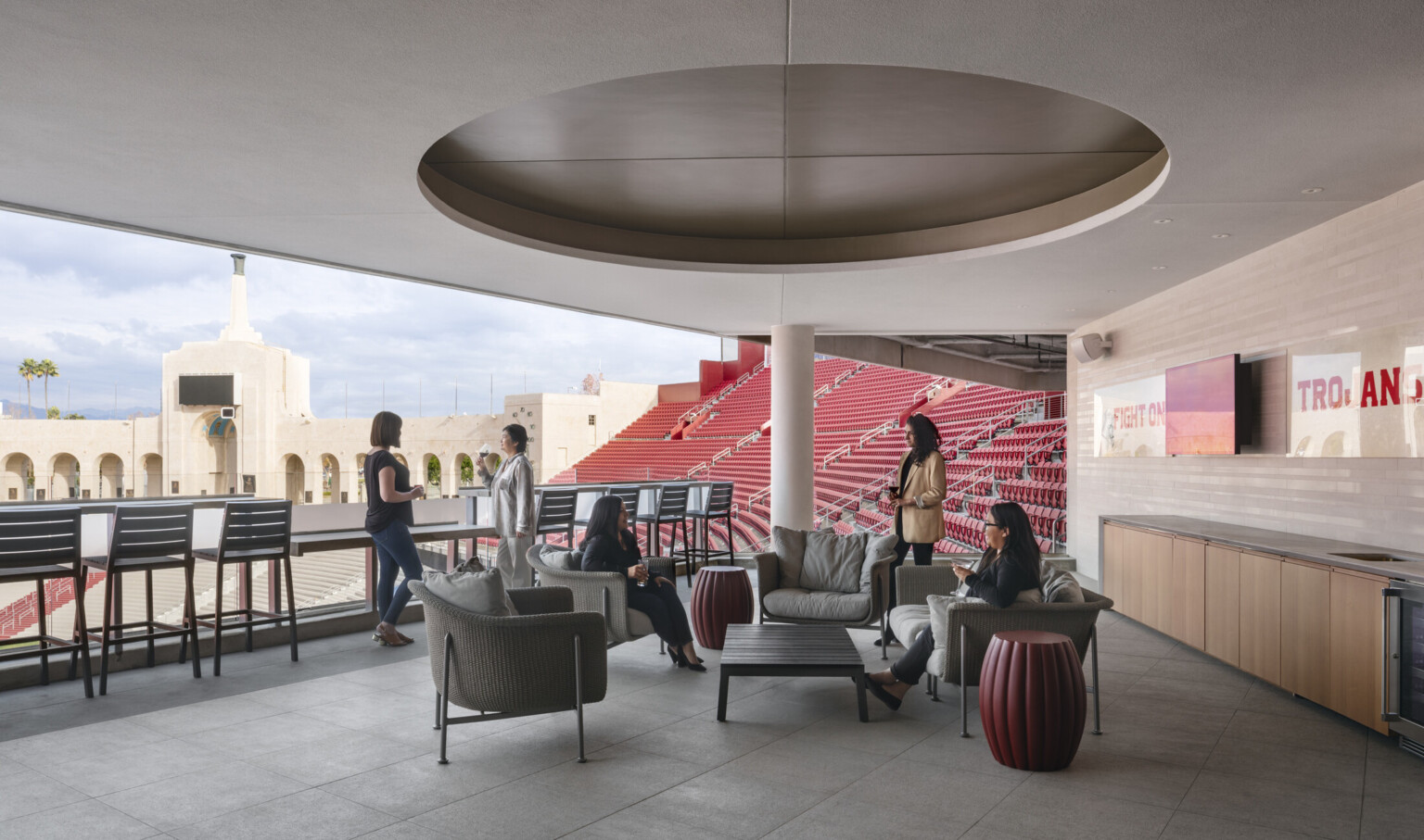 Covered seating area on balcony with round recessed ceiling detail on canopy. View of peristyle, back. Armchairs and stools