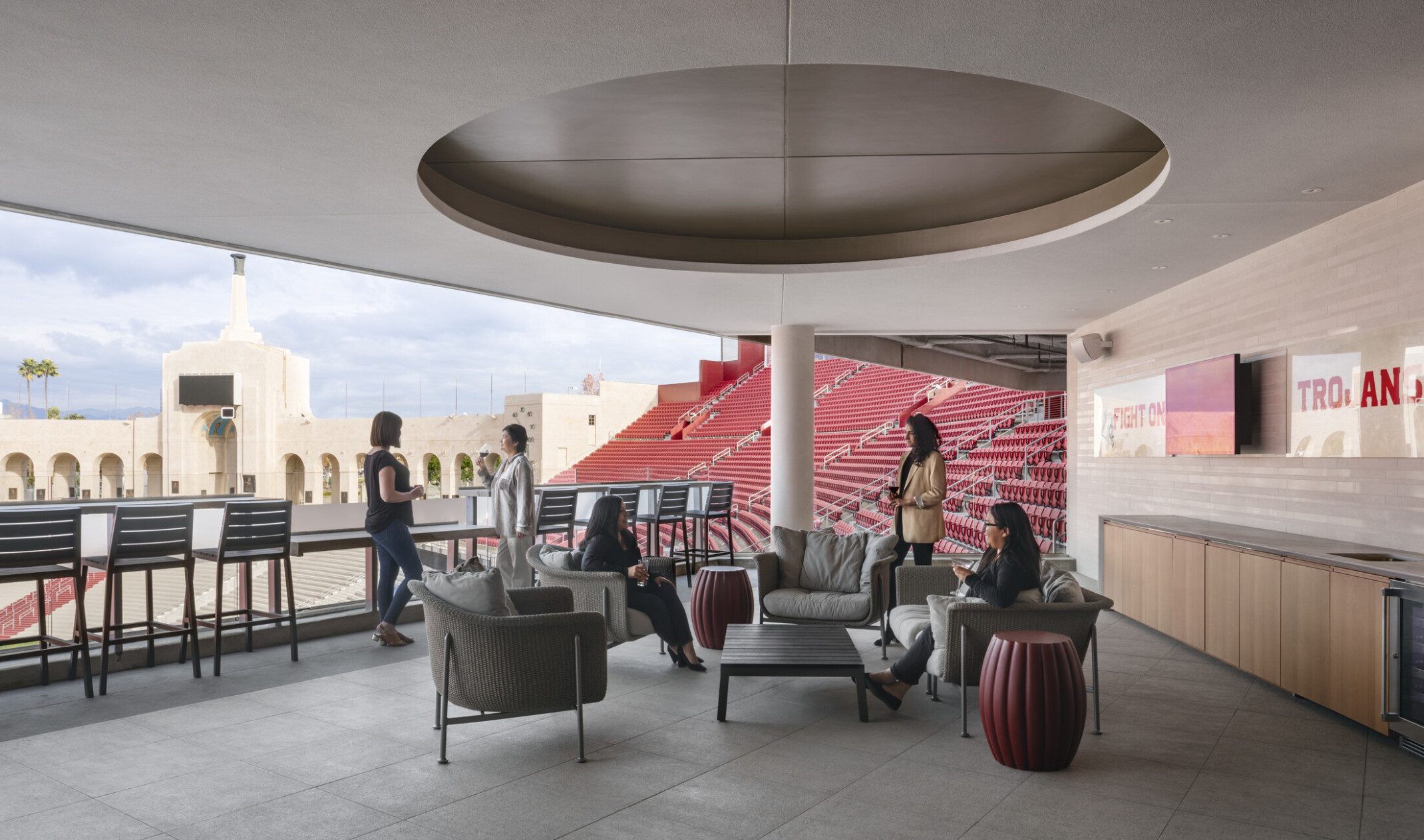 Covered seating area on balcony with round recessed ceiling detail on canopy. View of peristyle, back. Armchairs and stools