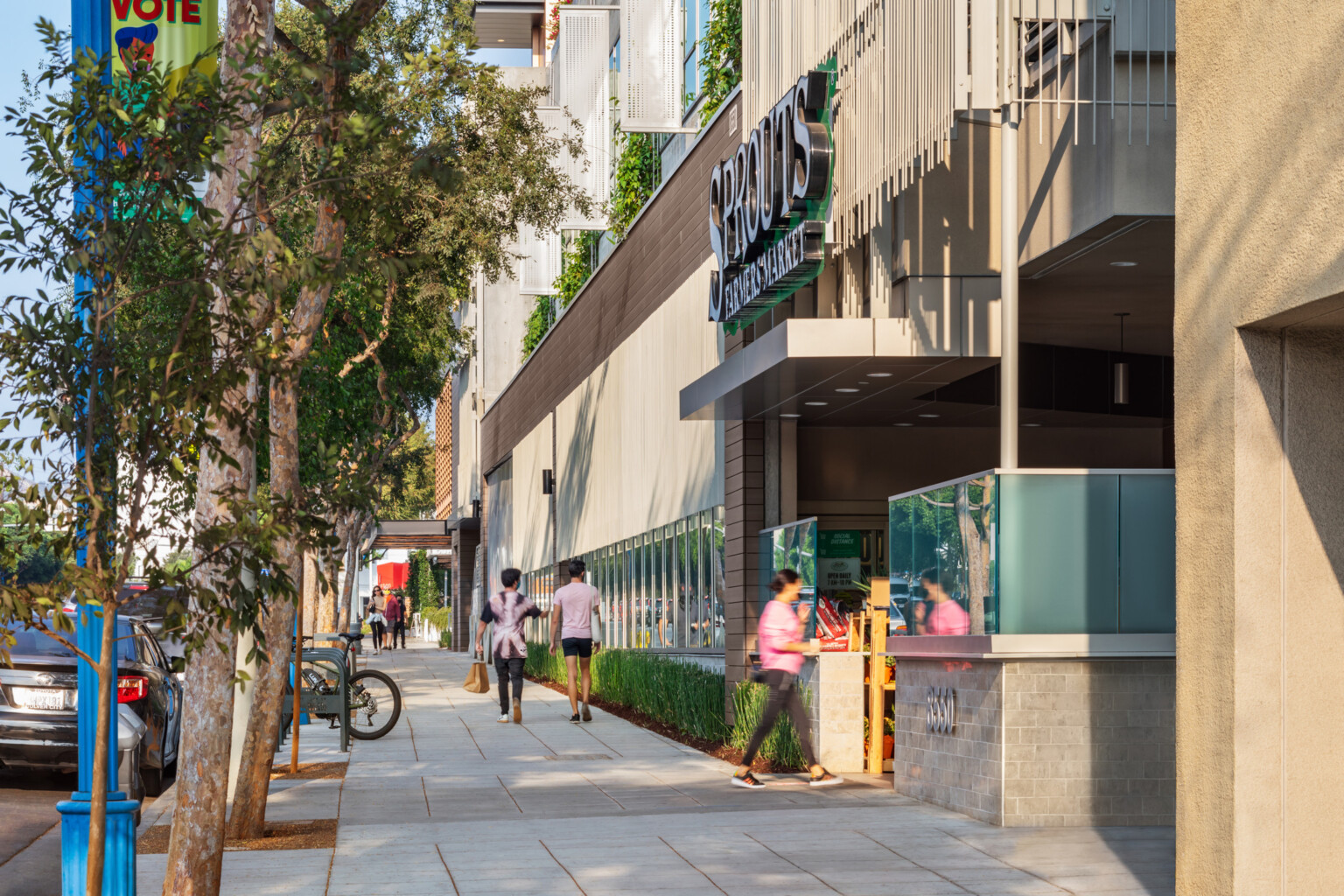 architectural rendering of a retail storefront; pedestrian walkway with greenery