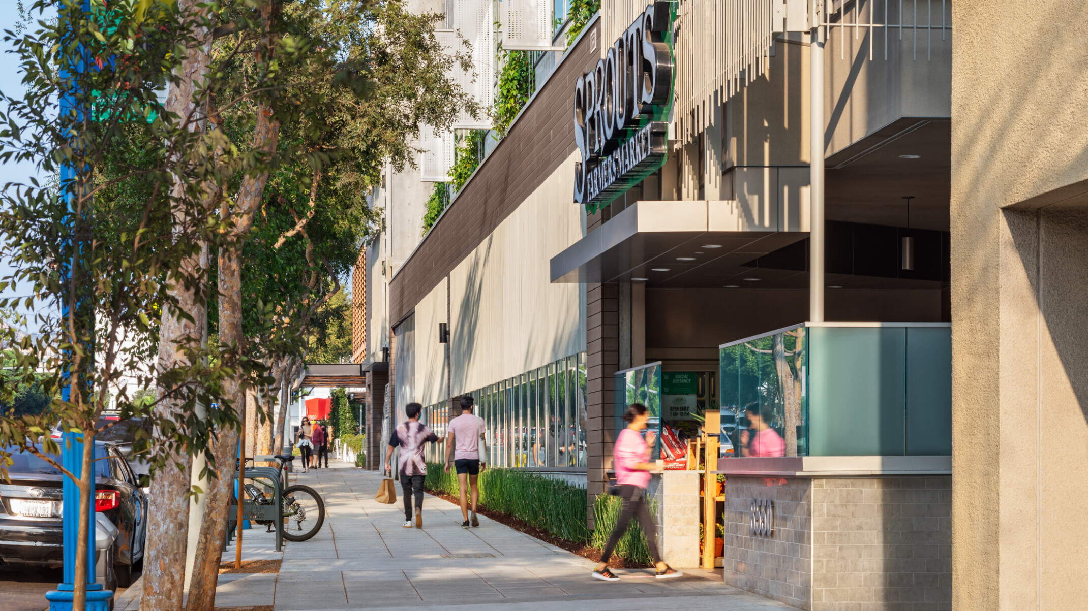architectural rendering of a retail storefront; pedestrian walkway with greenery