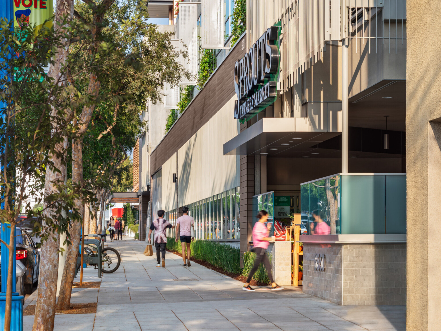 architectural rendering of a retail storefront; pedestrian walkway with greenery