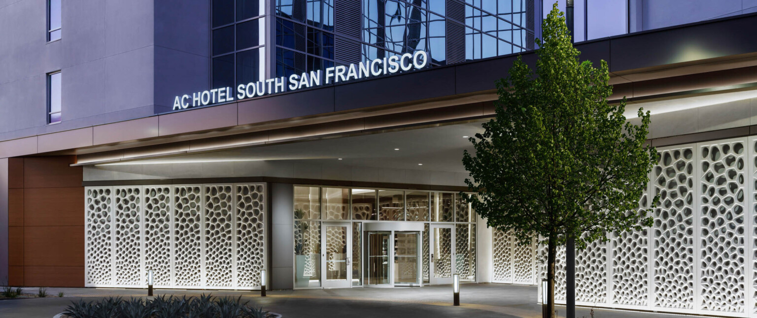 perforated white storefront flanking a circular driveway entrance following Marriott brand architecture