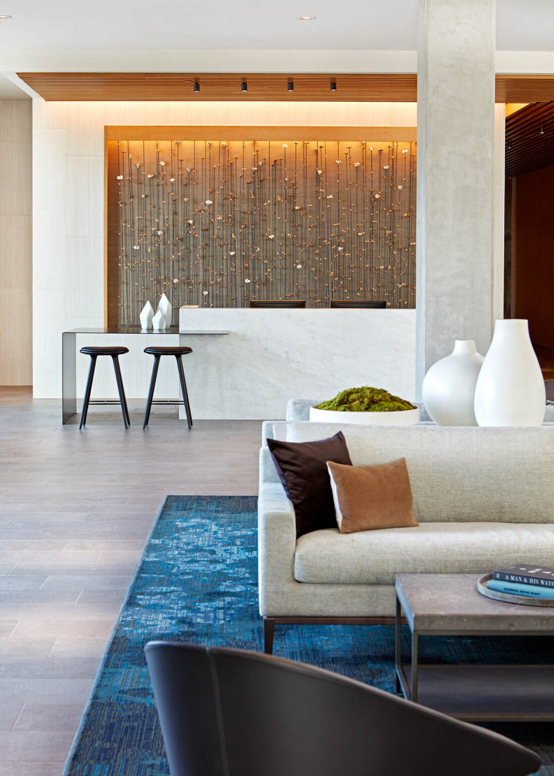 white reception desk with stools and lounge seating in the foreground