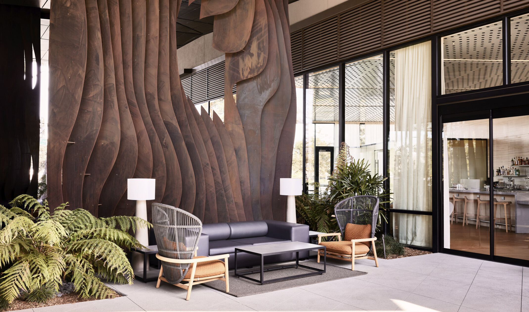 A two-story weathered steel form emerges from the ground creating intrigue within the central breezeway activating the public space.