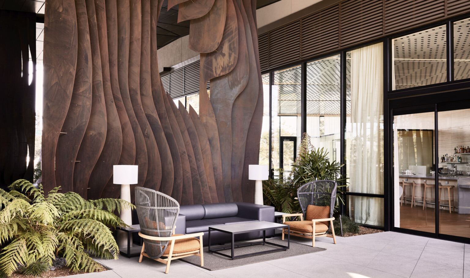 A two-story weathered steel form emerges from the ground creating intrigue within the central breezeway activating the public space.