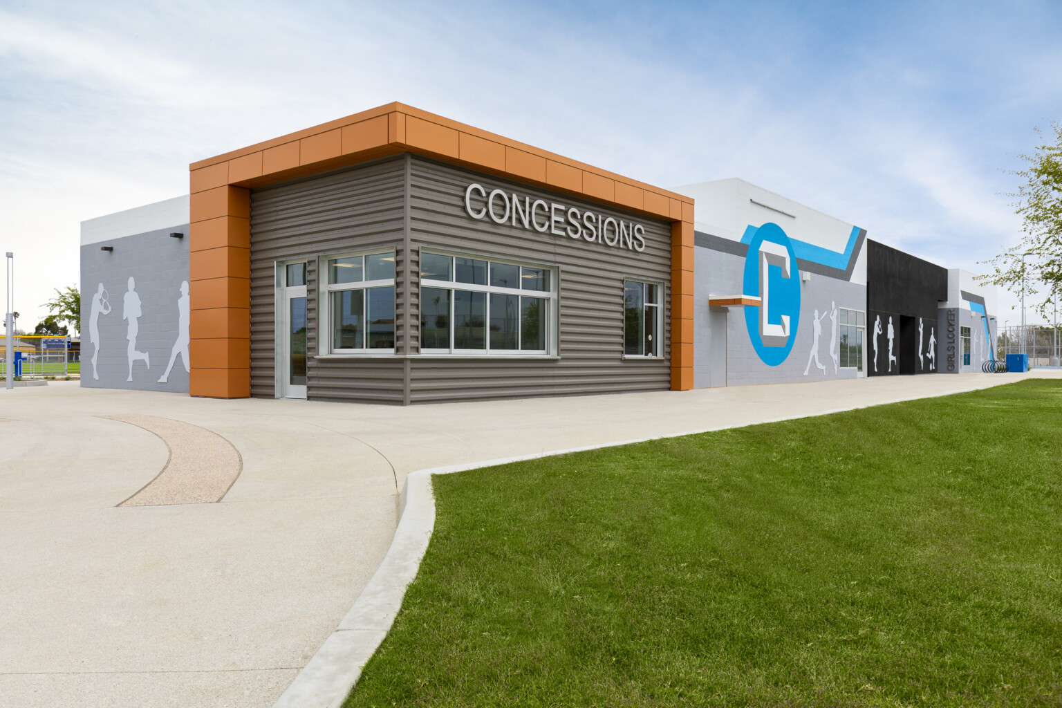 Compton High School concession stand; modern sports logo for Compton "C" on the building; blue and orange features against neutral building colors