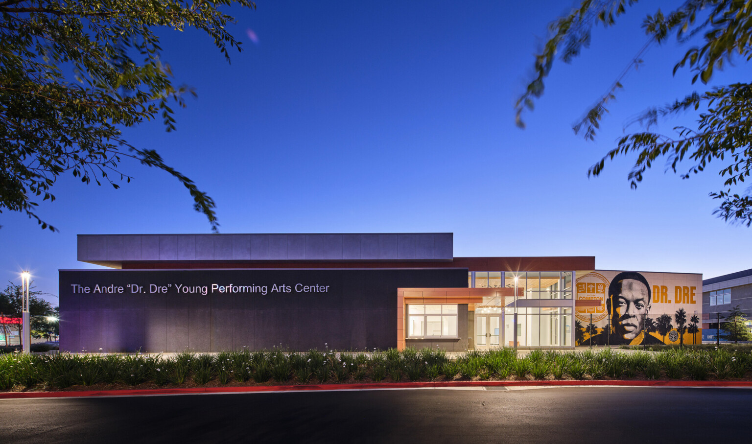 Compton High School Andrew "Dr. Dre" Young Performing Arts Center entrance; modern building with a Dr. Dre mural on the front facing exterior wall; performing arts community center