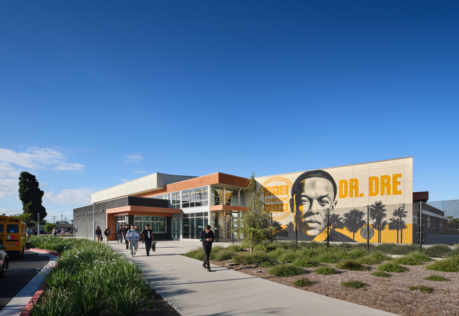 Compton High School Andrew "Dr. Dre" Young Performing Arts Center entrance; modern building with a Dr. Dre mural on the front facing exterior wall; performing arts community center