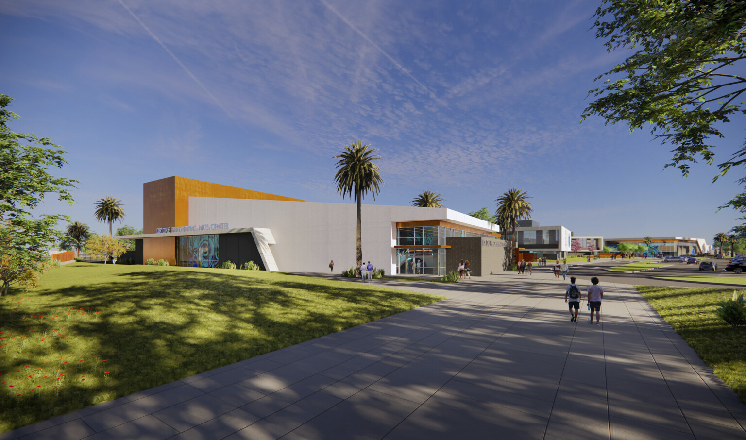 Corner view of building labeled Dr Dre Performing Arts Center. Angled white wrapped facade with brown details and mural left