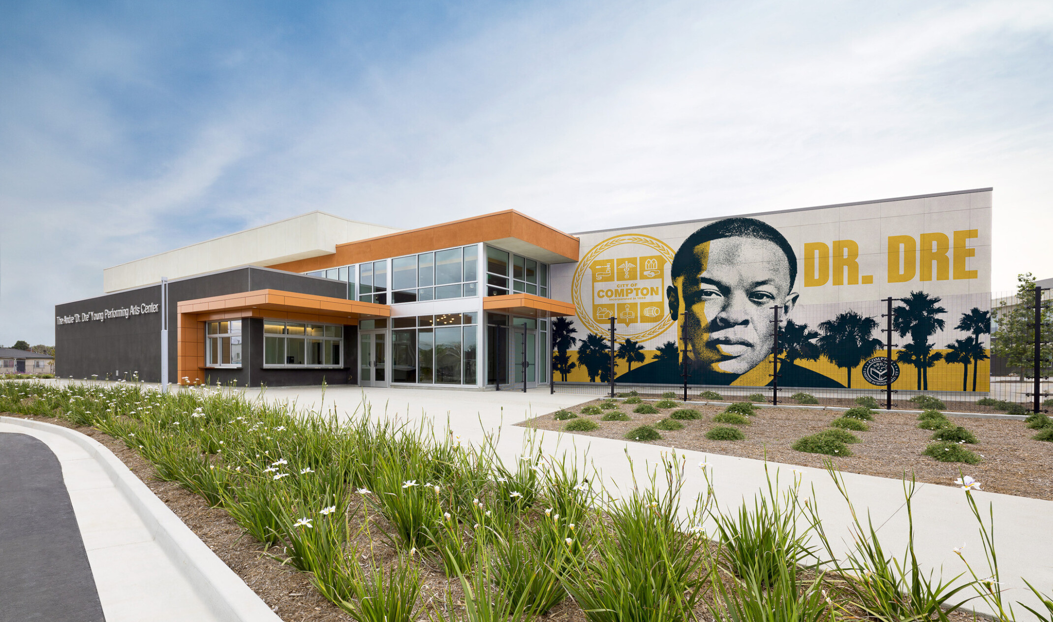 Compton High School Andrew "Dr. Dre" Young Performing Arts Center entrance; modern building with a Dr. Dre mural on the front facing exterior wall; performing arts community center