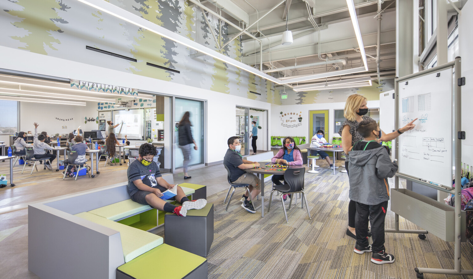 Bill Libbon Elementary School classroom; students in pods and classroom breakouts for diversified learning styles; green and gray designed school furniture; desks; sofas; whiteboards