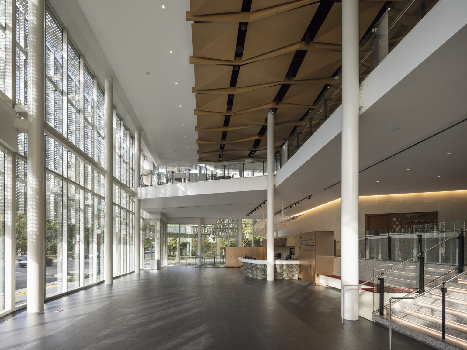interior lobby with double height floor to ceiling glass store fronts and custom wood ceiling over a mezzanine interior lobby with double height floor to ceiling glass store fronts and custom wood ceiling over a mezzanine