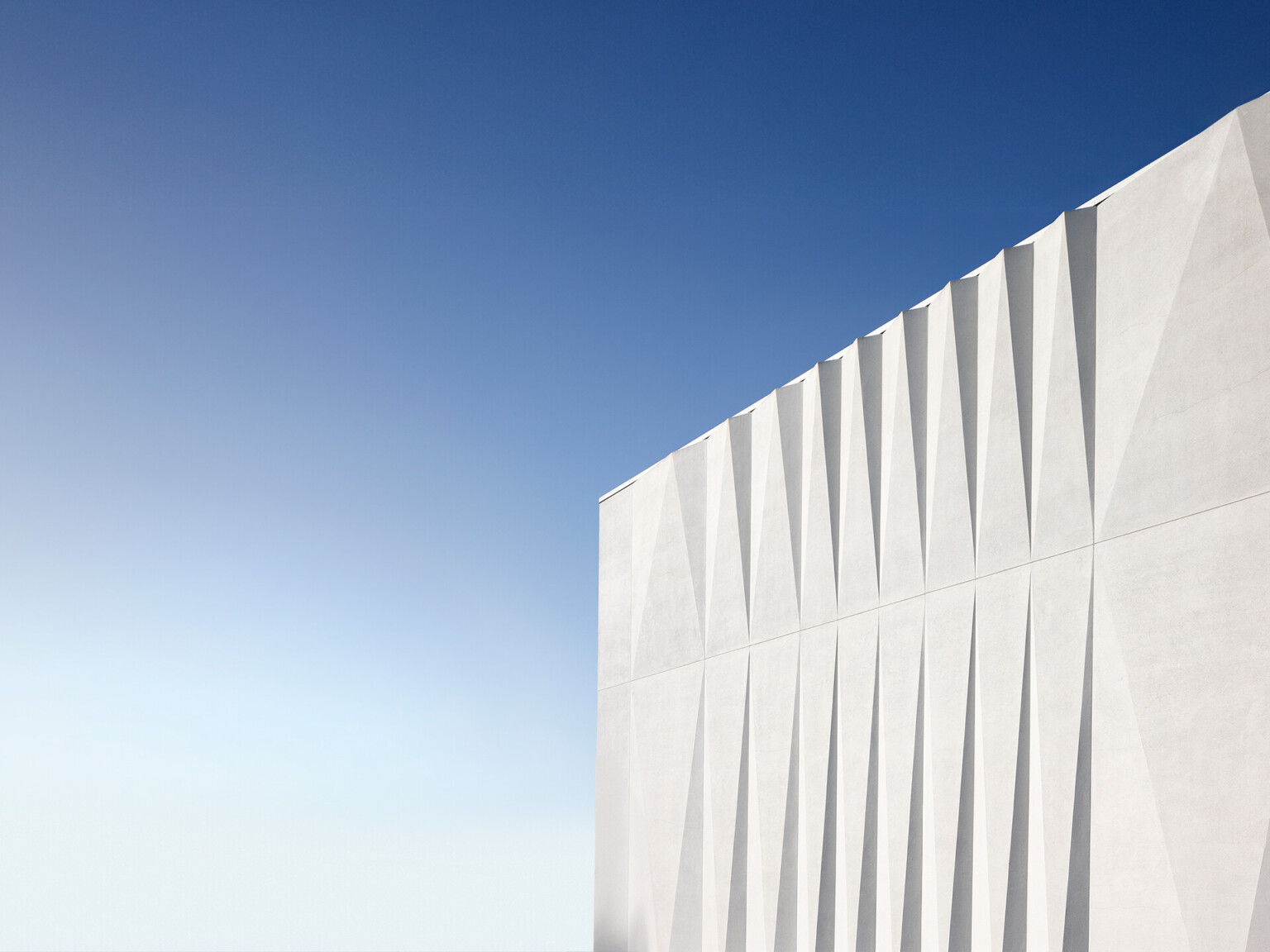 white angular facade against a blue sky