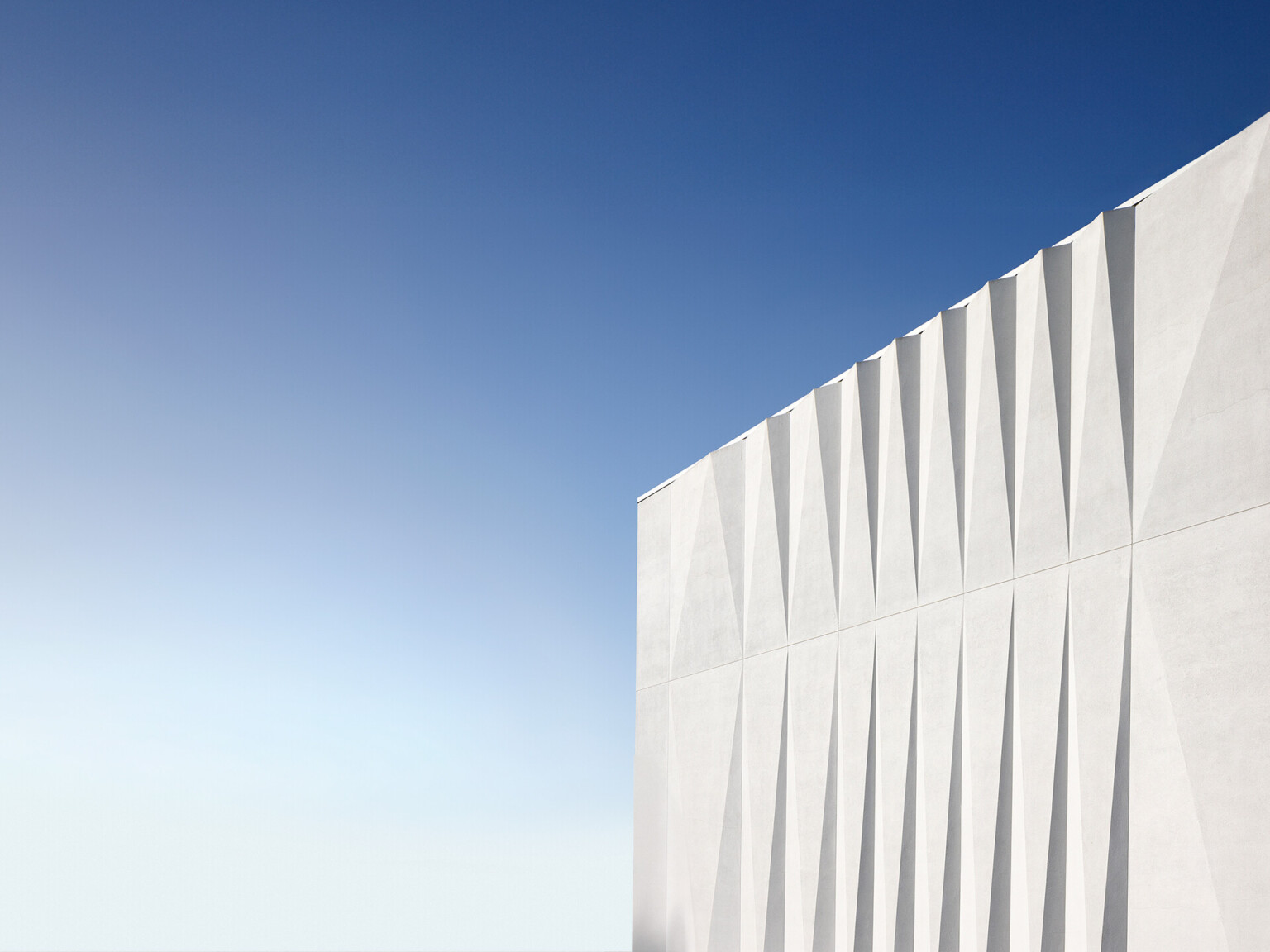 white angular facade against a blue sky