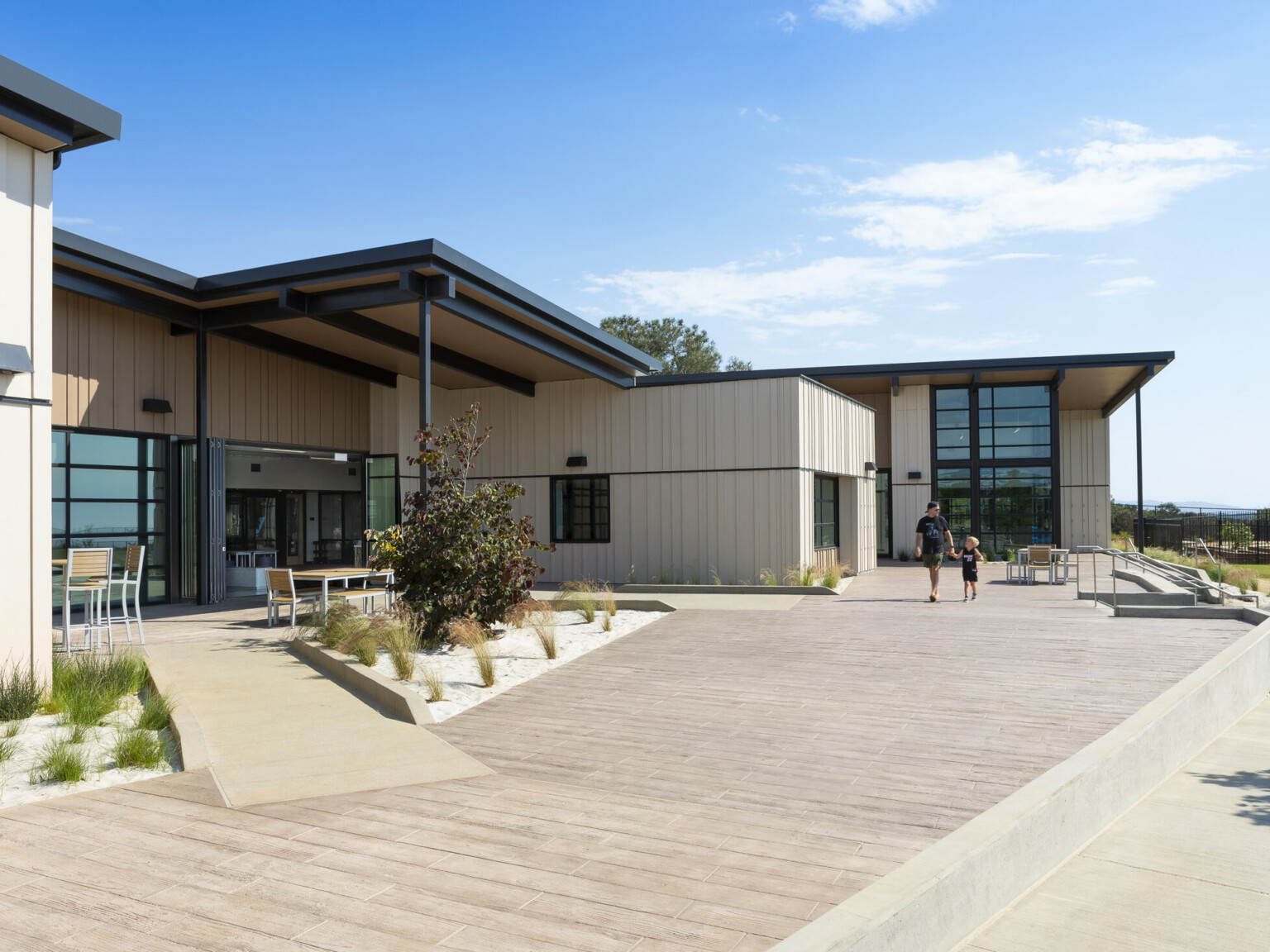 exterior of Del Mar Heights School, architecture inspired by California Coastal Architecture; indoor outdoor learning space with large openable windows; coastal community design with sand and wood tones with greenery exterior of Del Mar Heights School, architecture inspired by California Coastal Architecture; indoor outdoor learning space with large openable windows; coastal community design with sand and wood tones with greenery