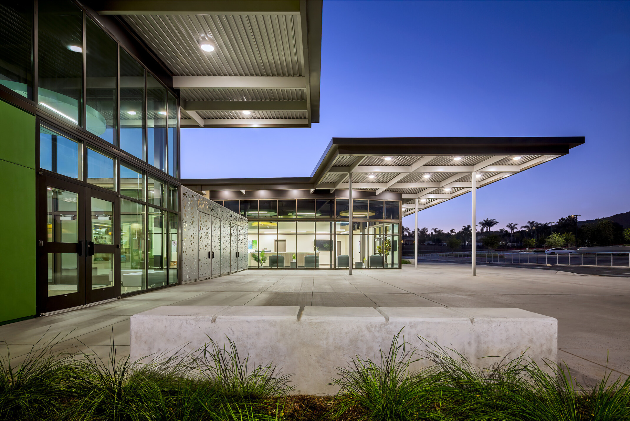 Canopy over Richland Elementary School exterior entrance to campus patio; illuminated in the evening; large floor to ceiling windows