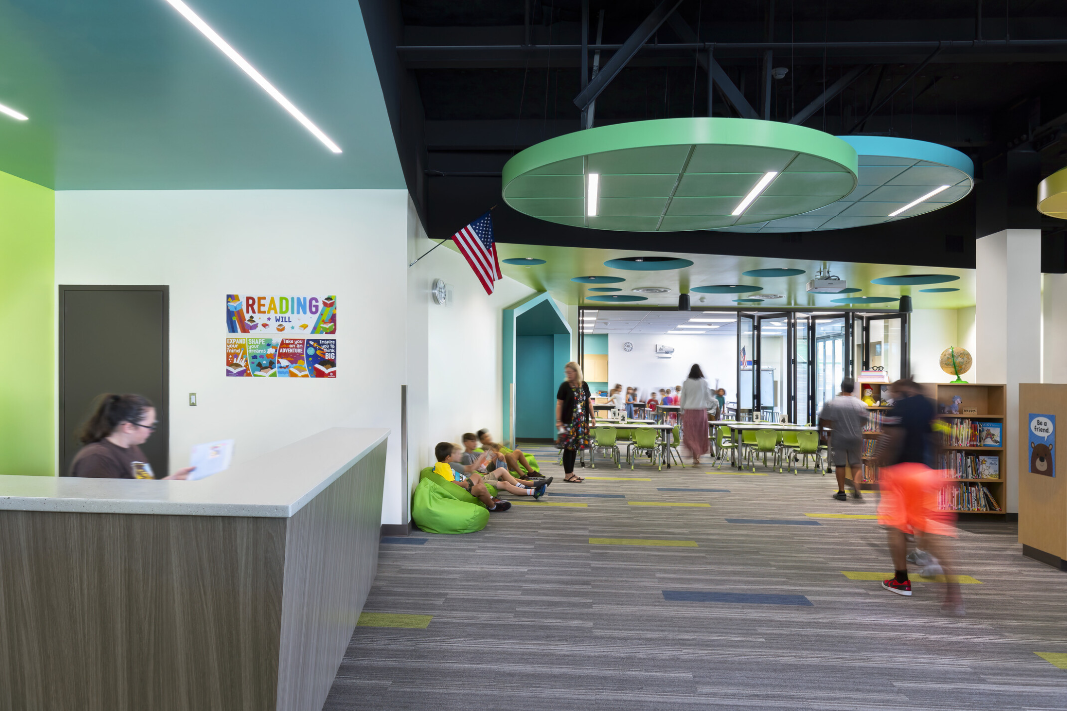 blue and green textured acoustic panels in hallway of Richland Elementary School; shelves of books and mixed comfortable seating areas; learning space; beanbag chairs
