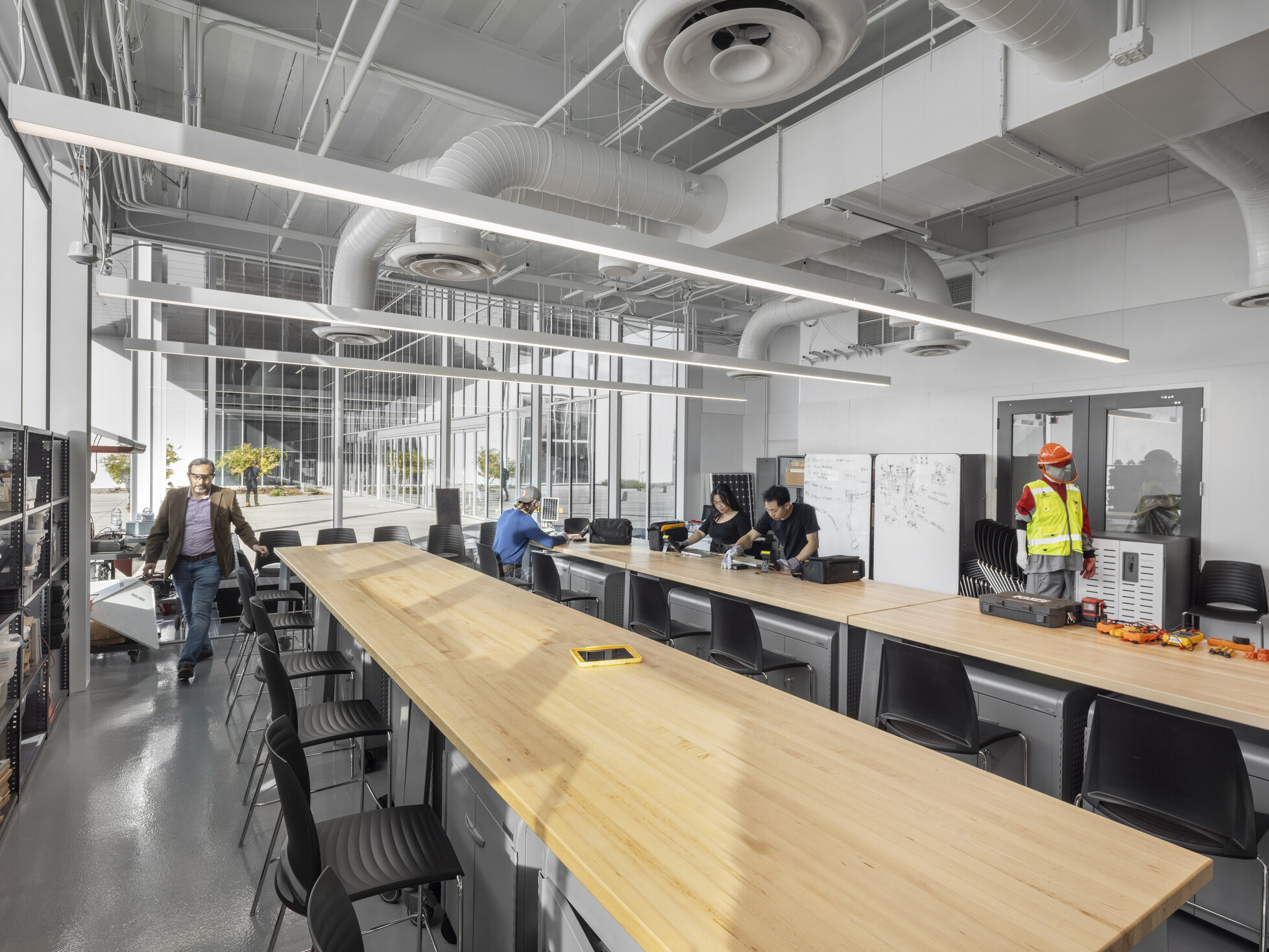 interior classroom of a technical career education space; industrial feel with large collaboration tables