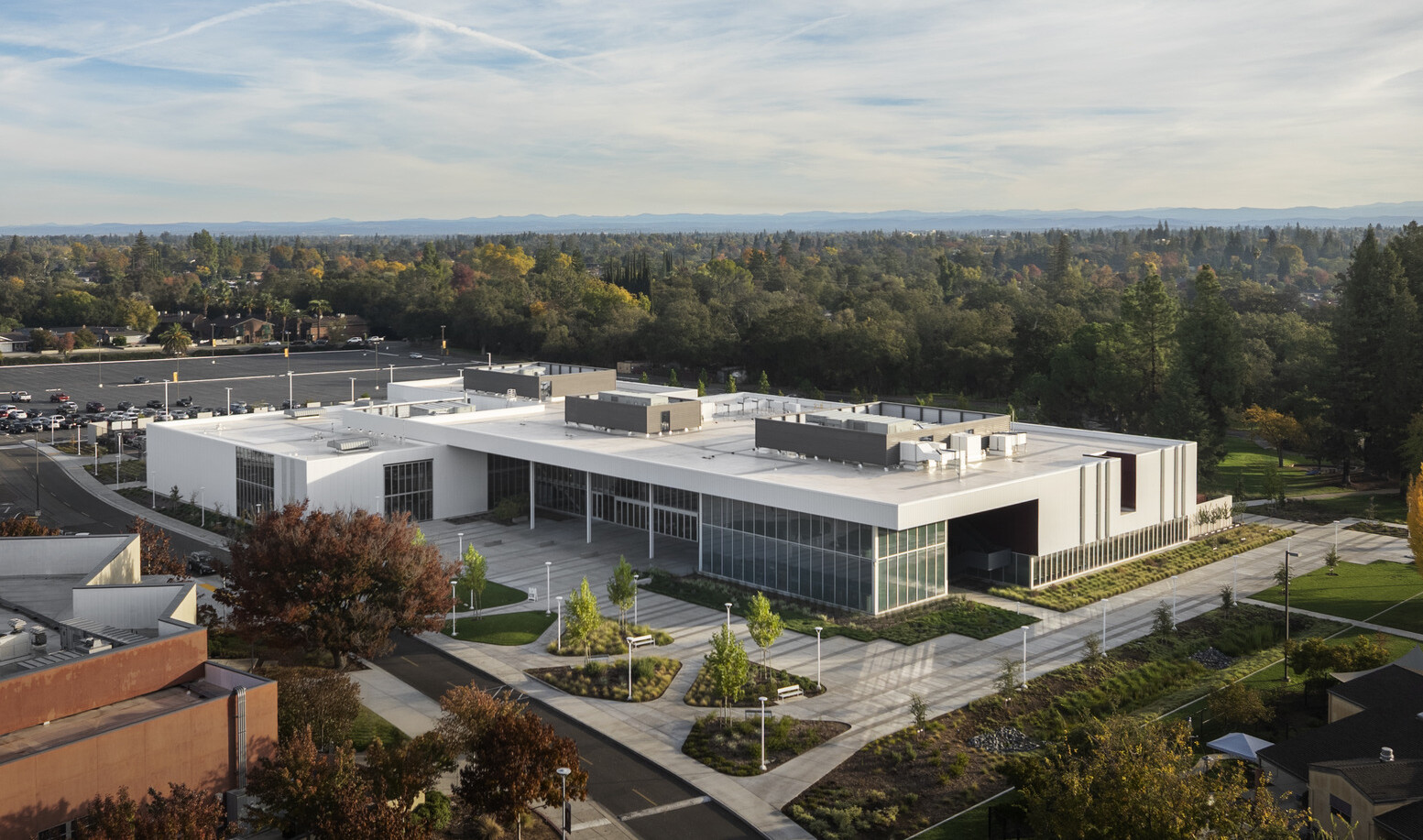 aerial view of a modern academic building; rectangular building; white facade with recessed ground level and entrance glass walls