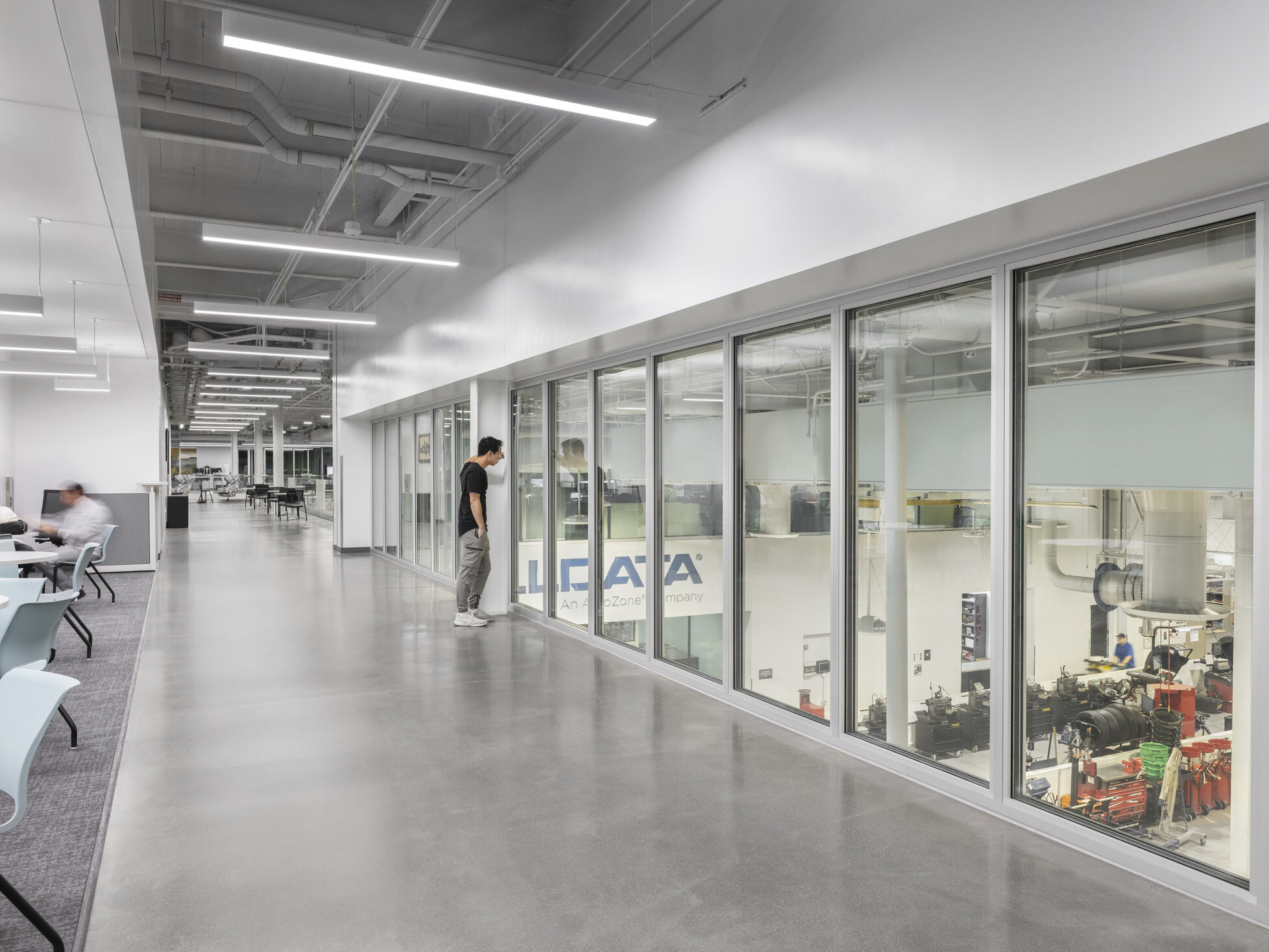 second story hallway overlooking technical workspace with floor to ceiling glass walls