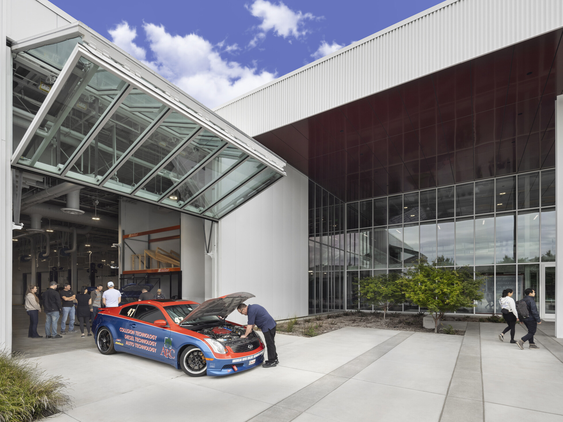 indoor/outdoor classroom of a technical career education space; motor vehicle work space; industrial feel with specialized tools and stations