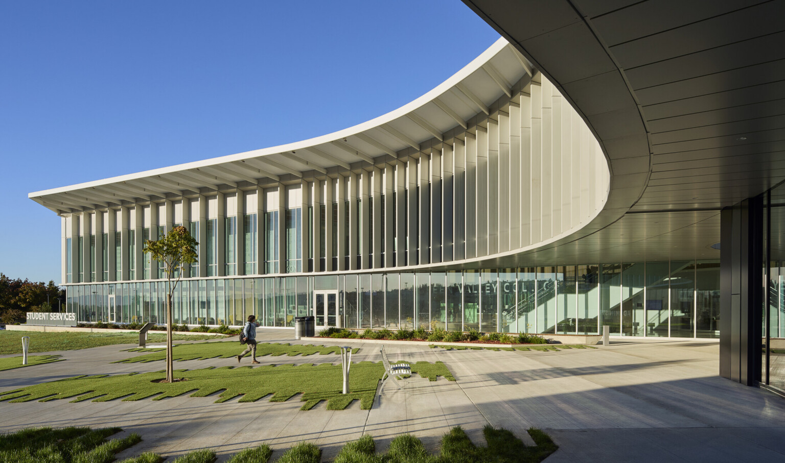 Multistory modern building with large glass panels and a curved roof