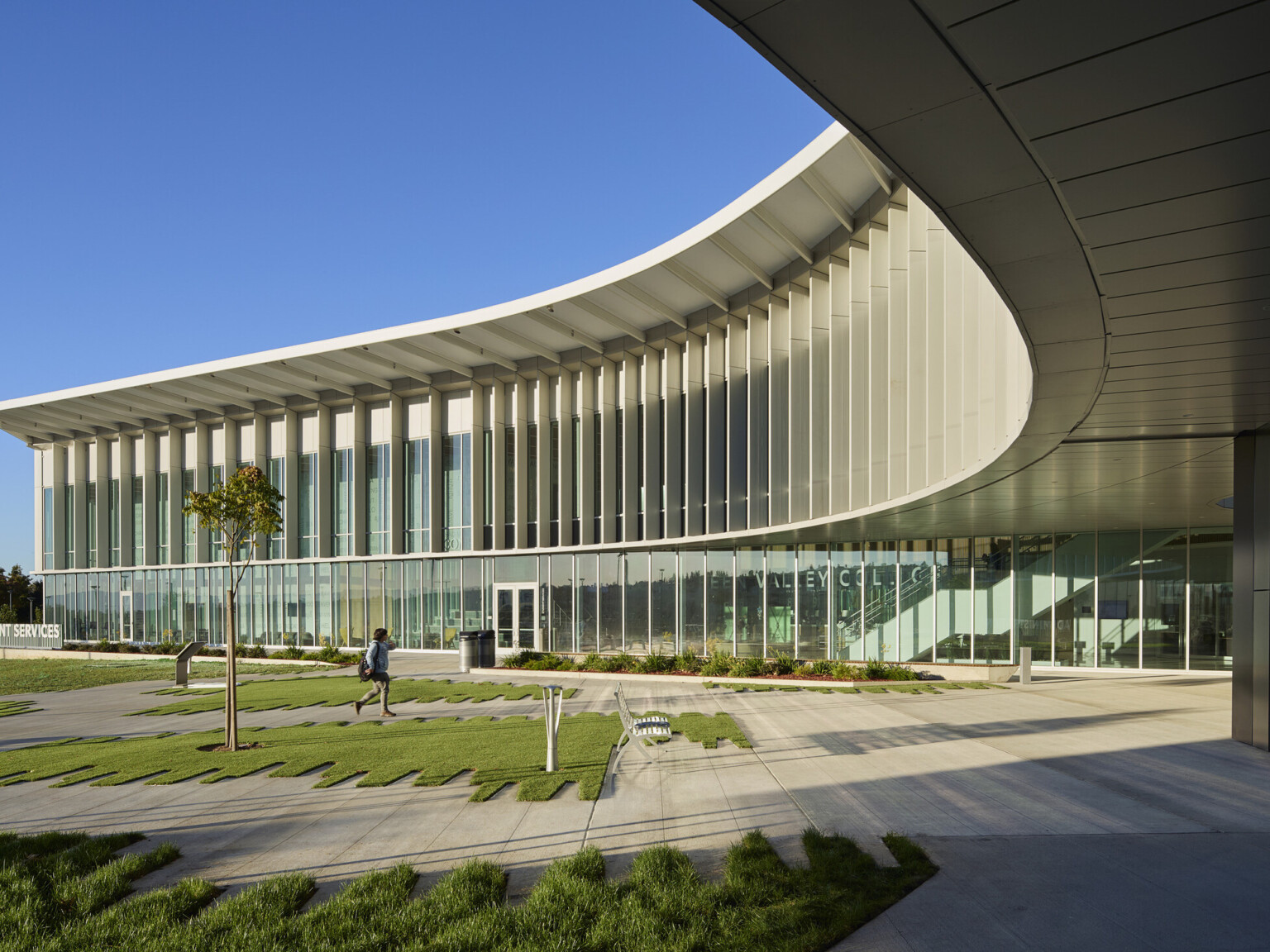 Multistory modern building with large glass panels and a curved roof