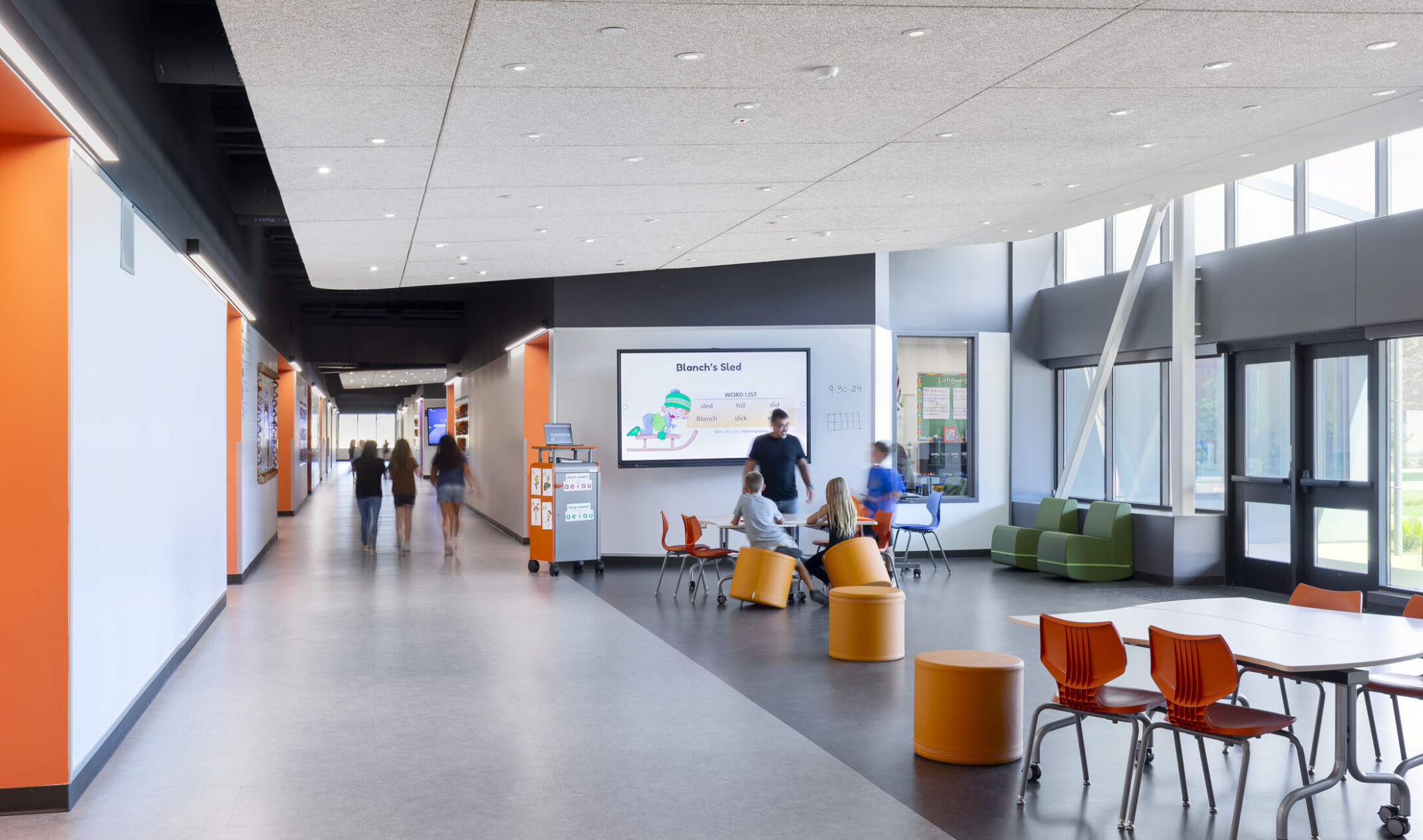Central area for students to gather and read; colorful modular furniture throughout