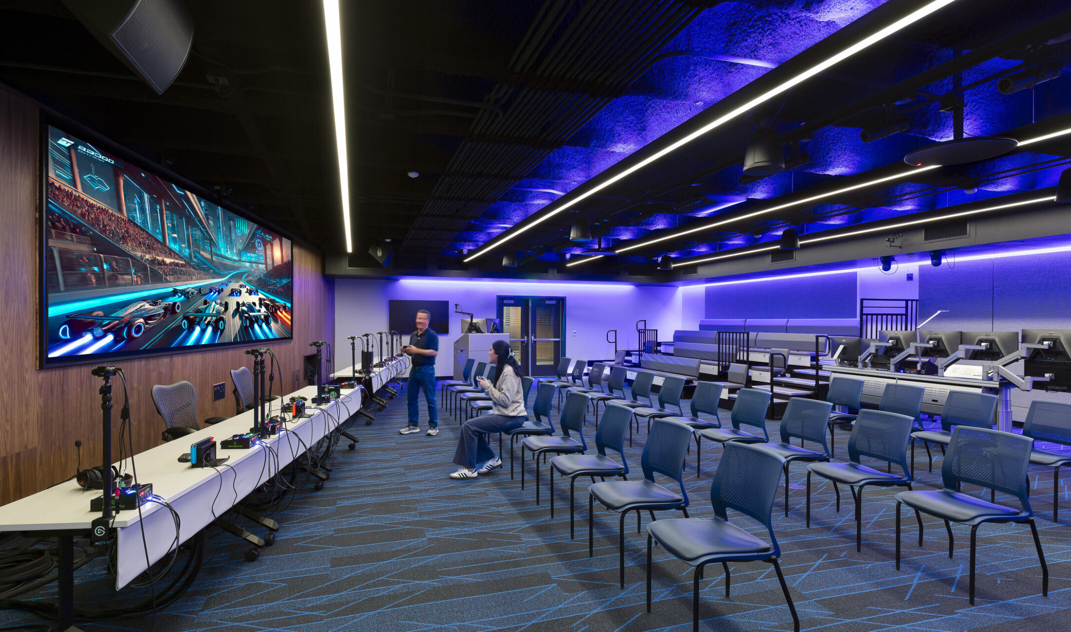 Lecture classroom with large screen and technology center at the front of the classroom
