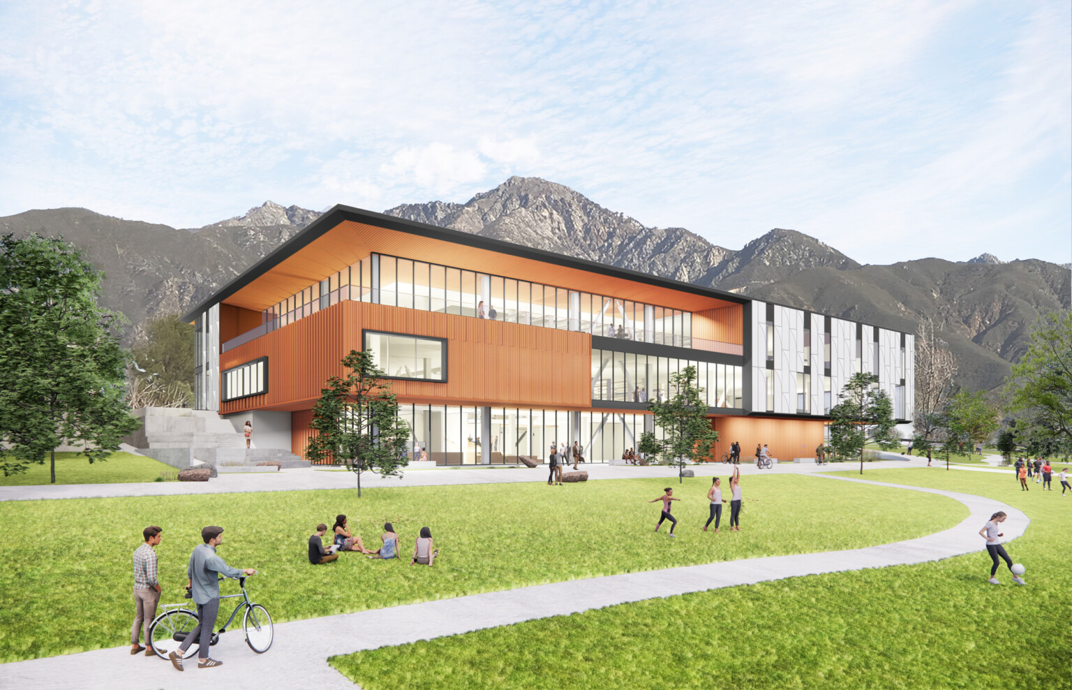 Exterior view of two-story library, mass timber, floor-to-ceiling glass fenestration, concrete walkway leads to entrance, people on the lawn, hills in the background, blue sky