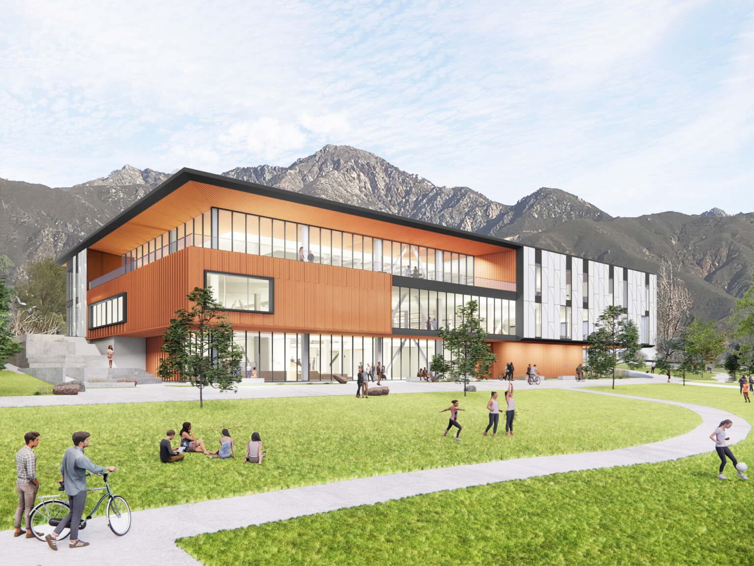 Exterior view of two-story library, mass timber, floor-to-ceiling glass fenestration, concrete walkway leads to entrance, people on the lawn, hills in the background, blue sky Exterior view of two-story library, mass timber, floor-to-ceiling glass fenestration, concrete walkway leads to entrance, people on the lawn, hills in the background, blue sky
