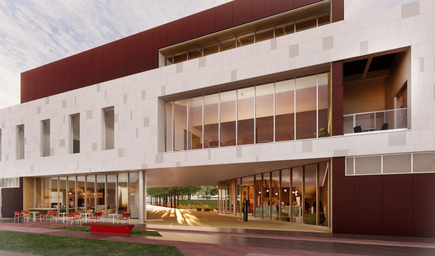 A close up view of the Stack’s entrance into its grand paseo and courtyard featuring tables and chairs, manicured lawns, and paved walkways