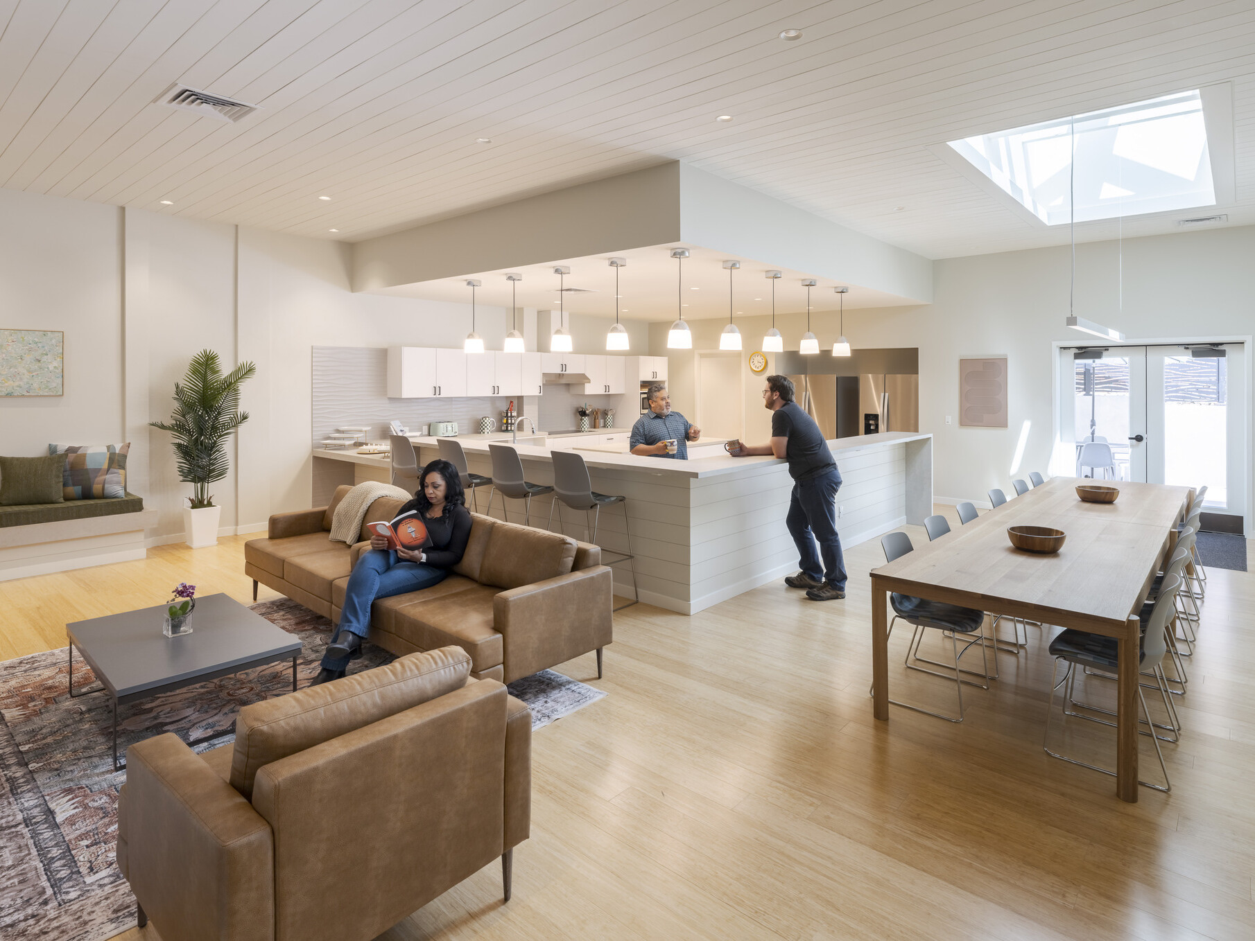 Bright multi-use space with a skylight, natural light, and warm-toned furniture creating a calming atmosphere.