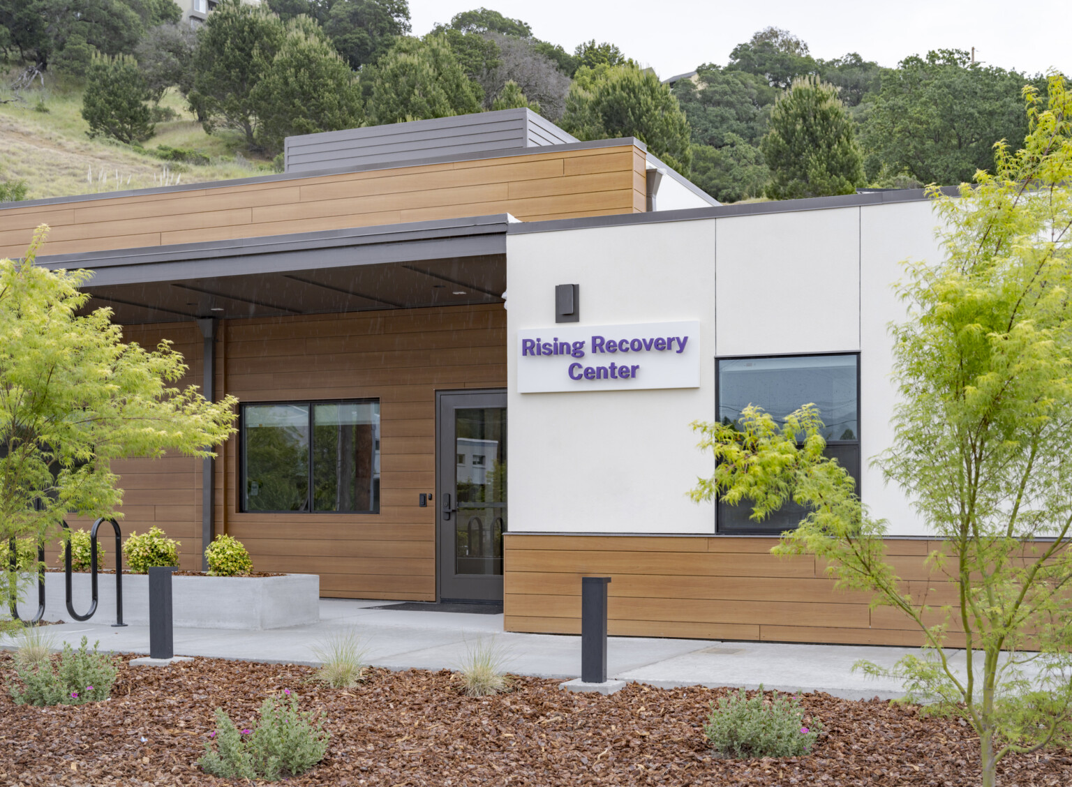 front entrance of the community-based behavioral health facility, Rising Recovery Center, from a repurposed San Rafael, CA fire station; walkway to a recessed covered doorway