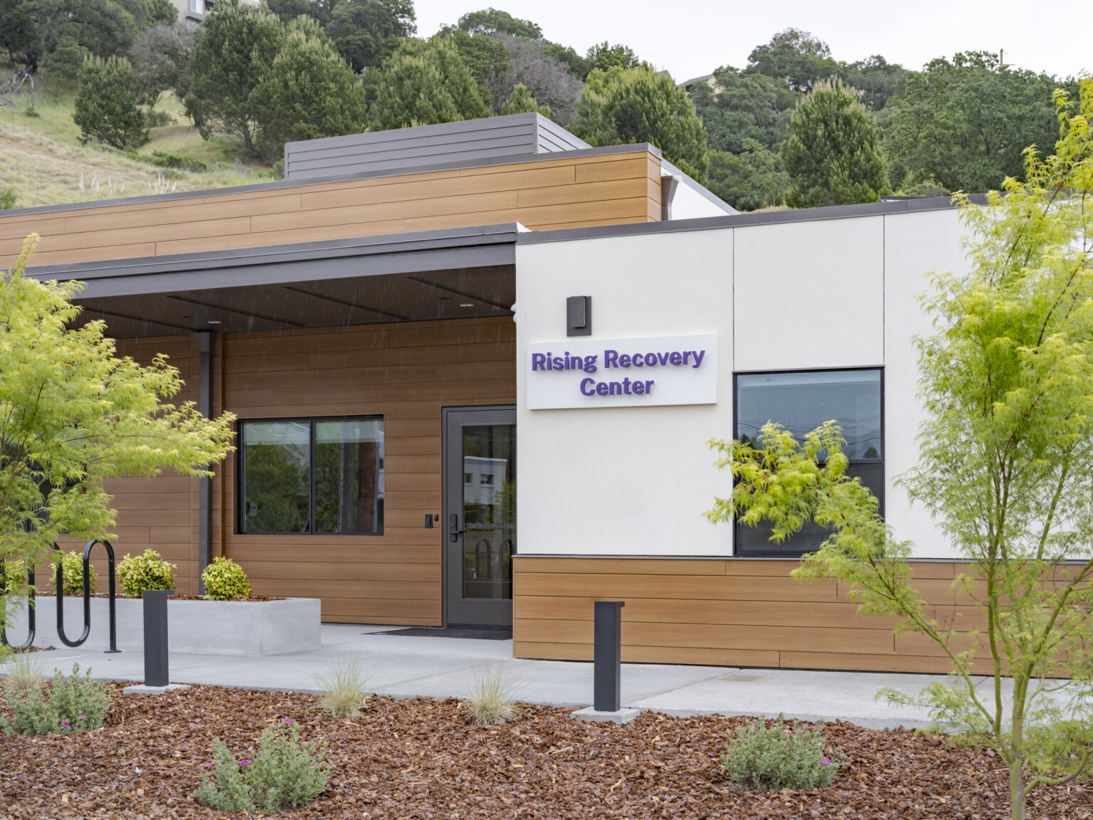 front entrance of the community-based behavioral health facility, Rising Recovery Center, from a repurposed San Rafael, CA fire station; walkway to a recessed covered doorway