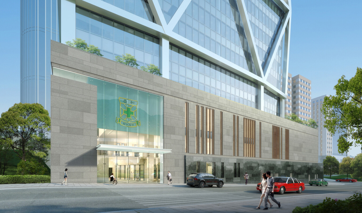 A modern building with a glass façade and a large entrance area. A logo featuring a shield and text is displayed above the entrance. People are walking on the sidewalk in front of the building, and several cars are parked or driving by.