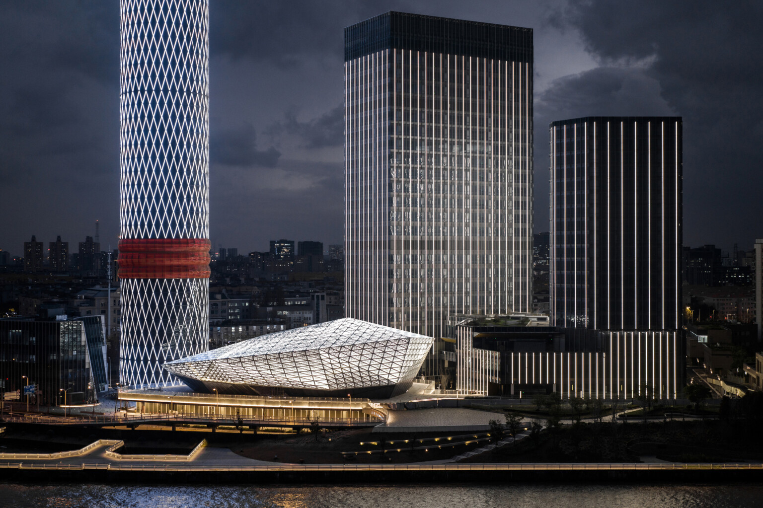Baoshan Long Beach Complex illuminated at night along Shanghai's Yangtze River, diamond geometric light on cylindrical tower Baoshan Long Beach Complex illuminated at night along Shanghai's Yangtze River, diamond geometric light on cylindrical tower