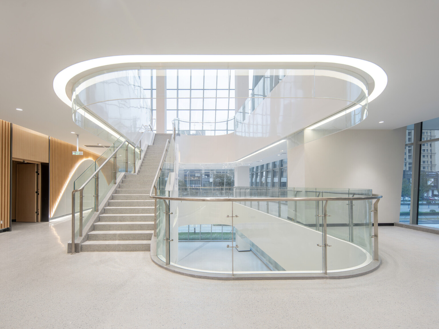Modern building stairway accented by white light, glass railings with silver accents