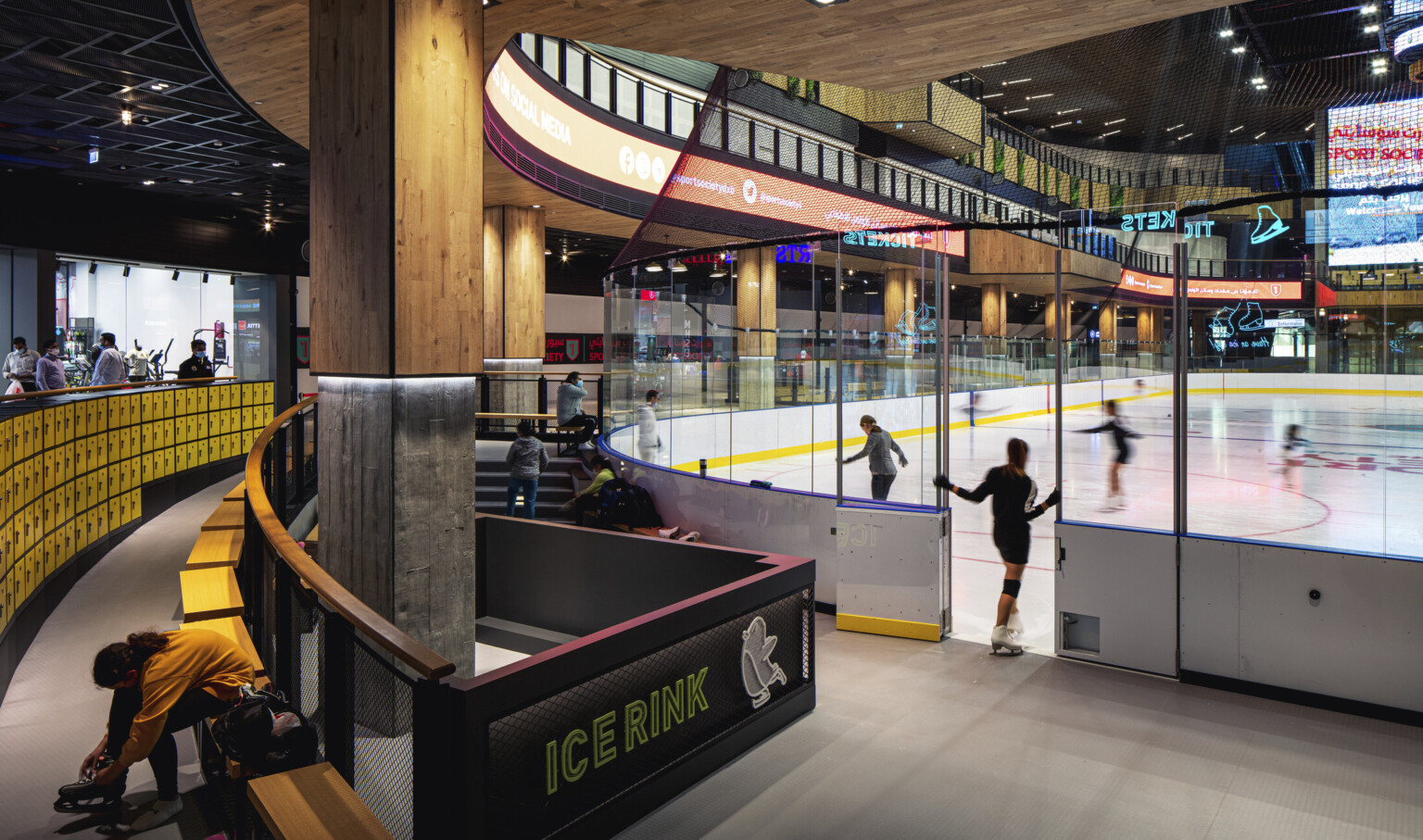Ice rink showing the ice with an entry door surrounded by glass and yellow accents