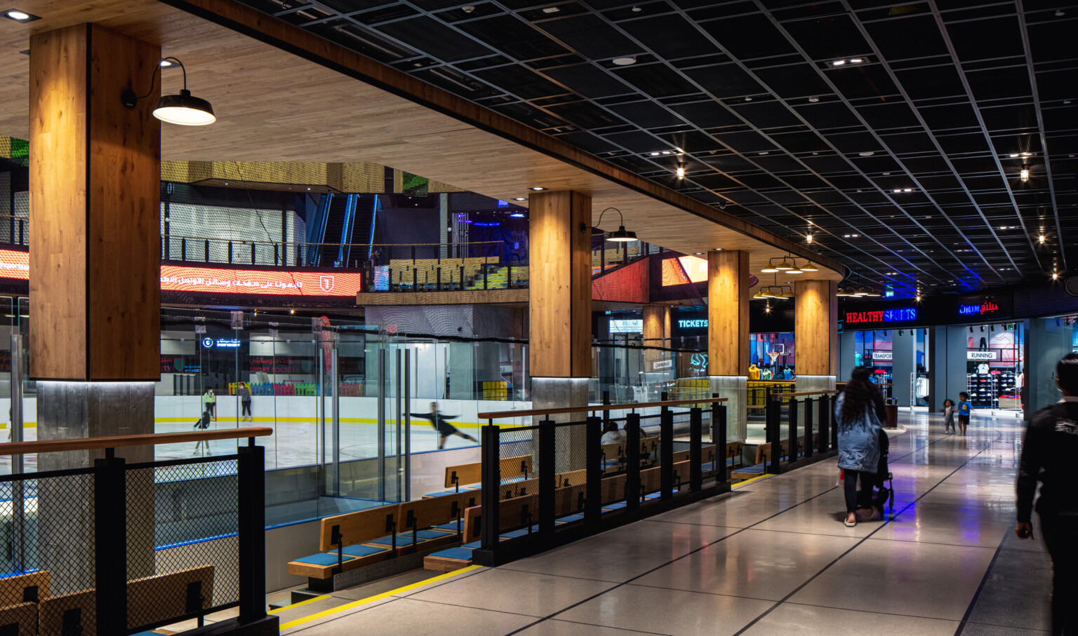 Ice rink showing the ice surrounded by glass with light wood columns with lights Ice rink showing the ice surrounded by glass with light wood columns with lights