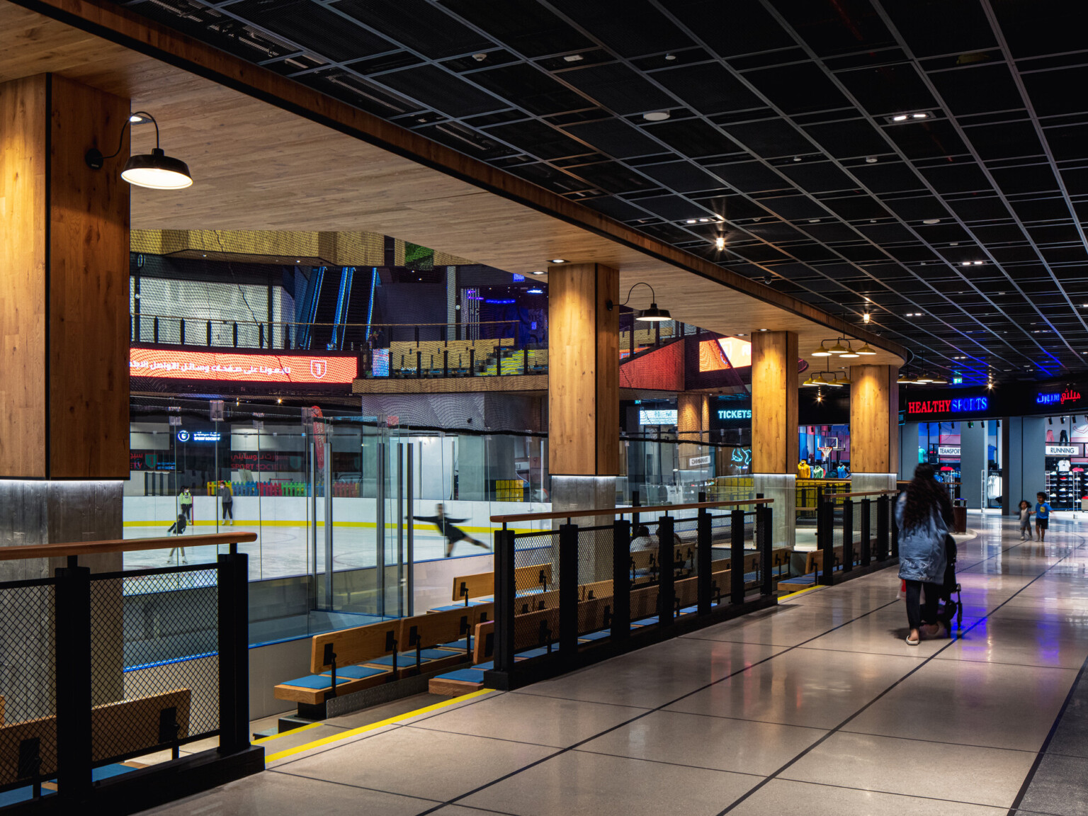 Ice rink showing the ice surrounded by glass with light wood columns with lights