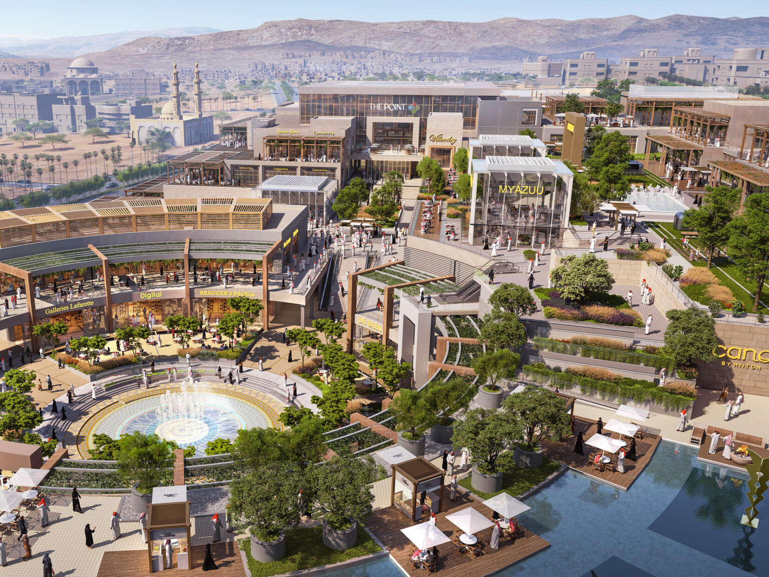 Aerial view of the campus plan built into a hill with rounded central courtyard lined with canopies, midrise buildings to left