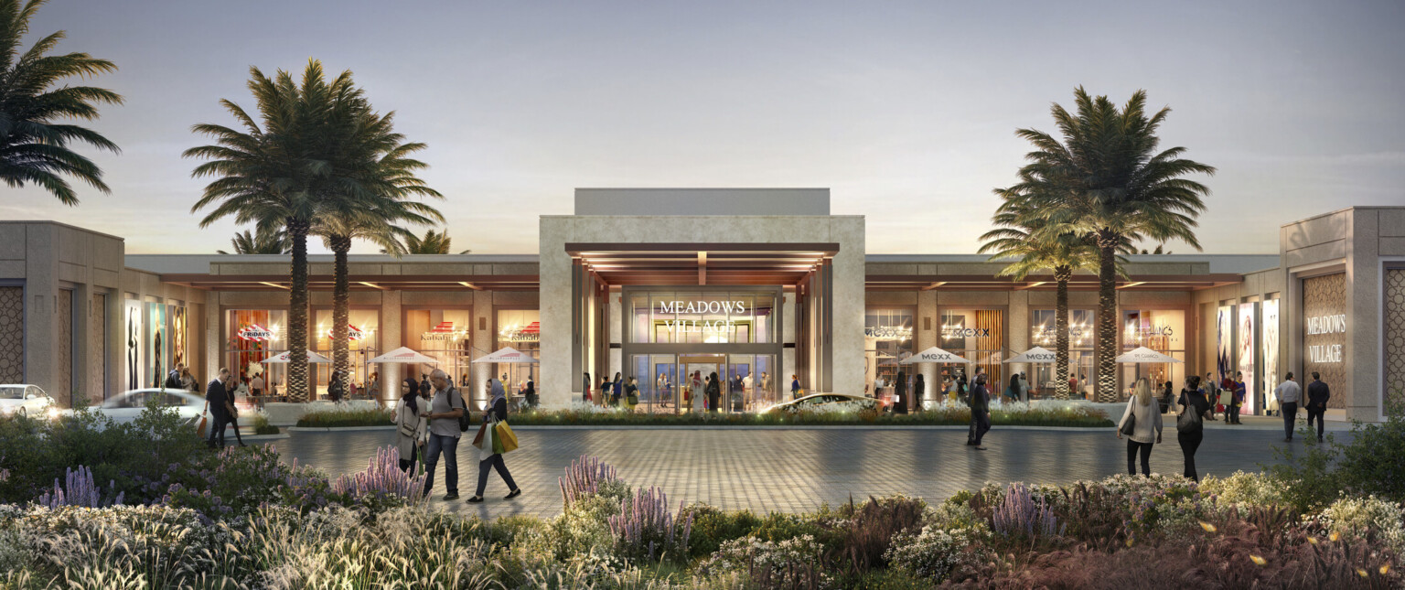 Pedestrians stroll toward a vibrant shopping center showcasing a variety of stores and a lively atmosphere.