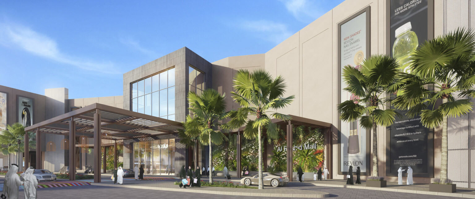 A mall exterior with cars and palm trees against a backdrop of sunny blue skies.
