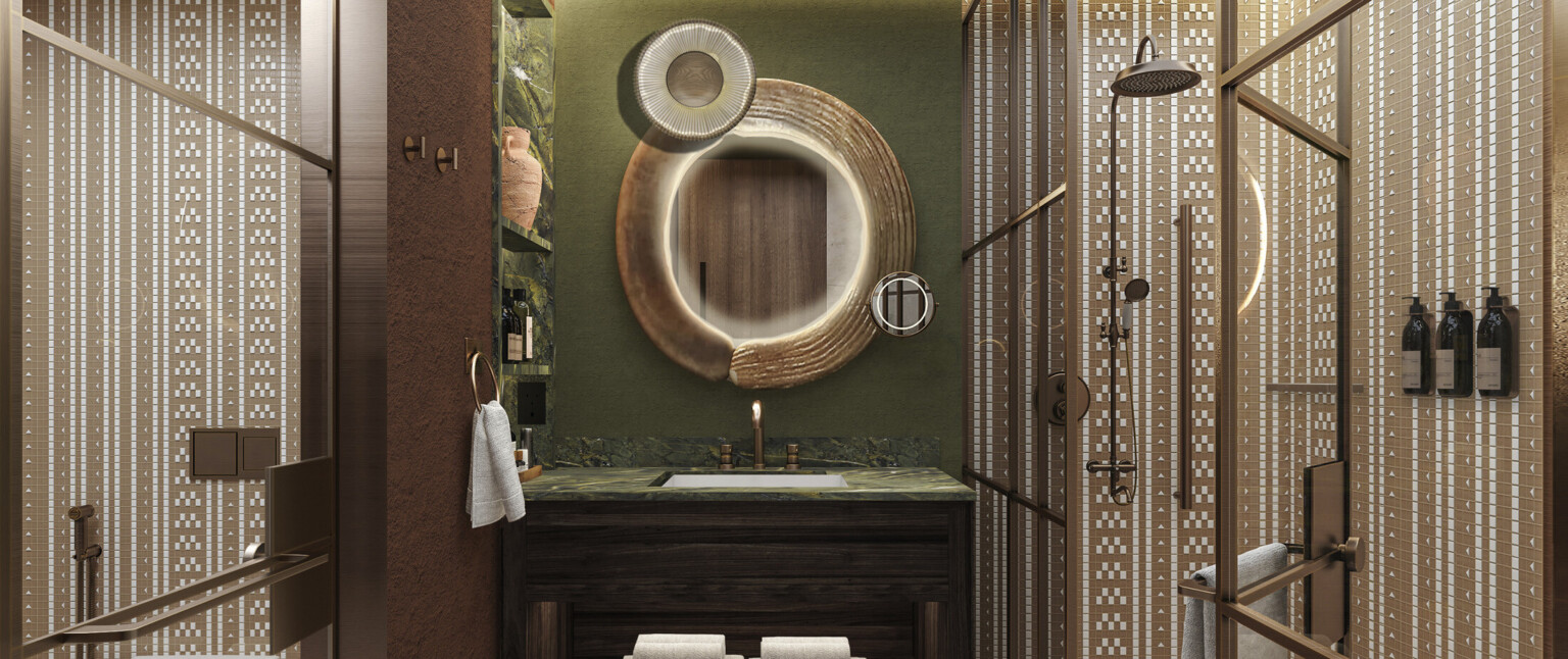 Hotel bathroom with gold accents, round mirrors, green wall and beige and white geometric tile