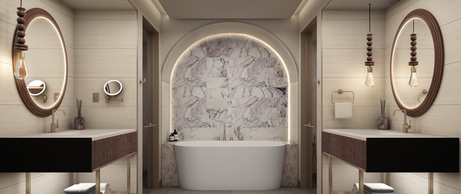 Hotel bathroom showing a large white bathtub and double sinks with dark wood accents