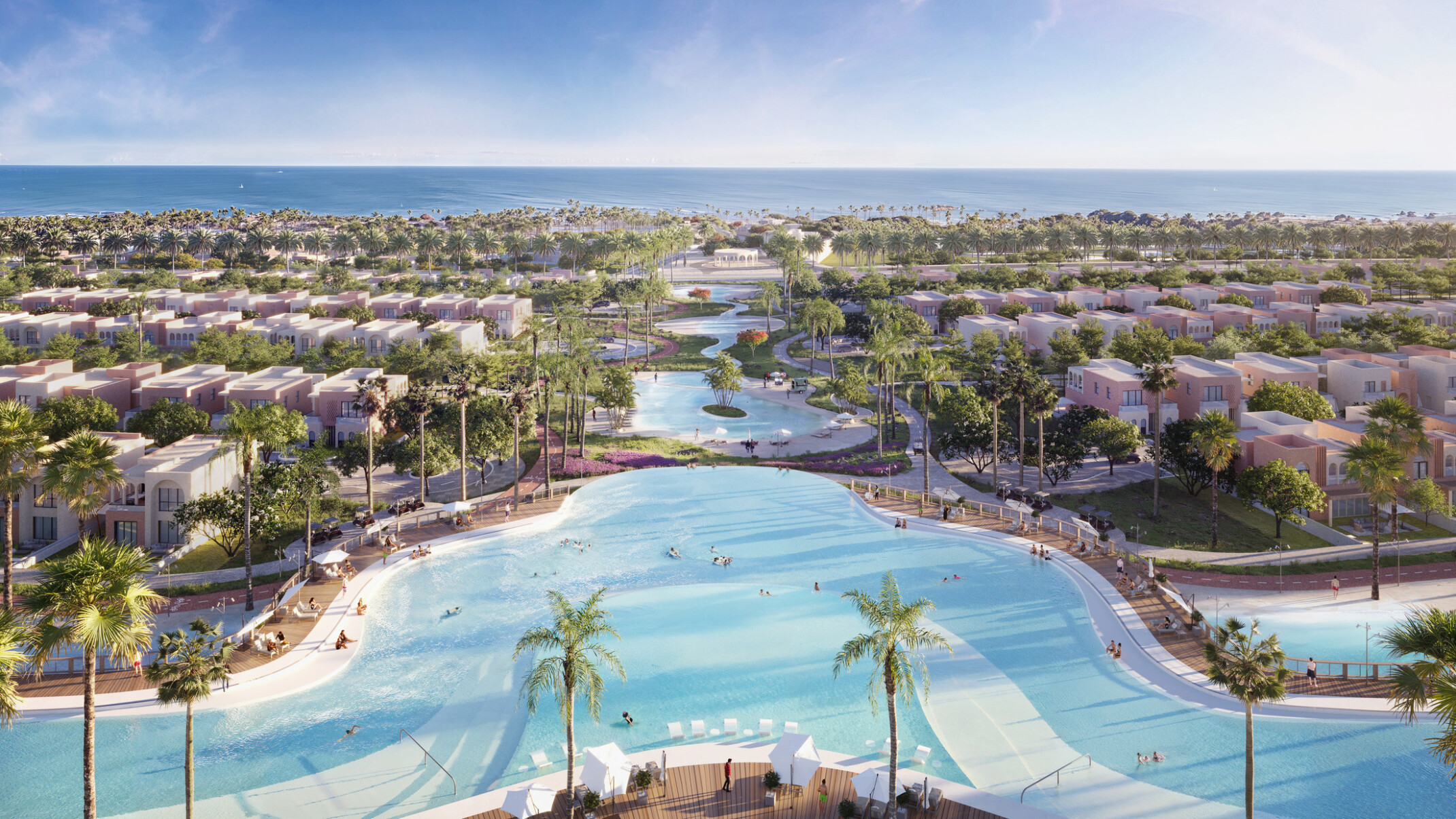 large curvy pool faces a neighborhood community split by the pool that flows into the background; people playing in the pool; pool area is surrounded by palm trees and pool chairs