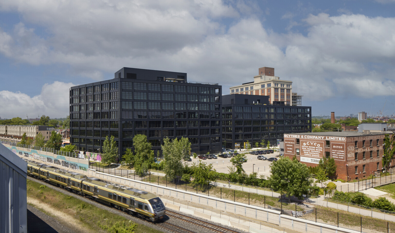 Aerial view of multiple black multistory buildings with a train running past Aerial view of multiple black multistory buildings with a train running past