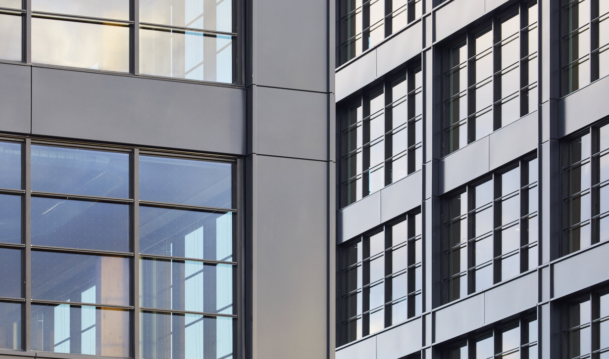 Aerial shot of the angles of black multistory buildings showing black framed windows